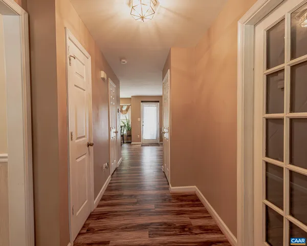 a view of a hallway with wooden floor and staircase
