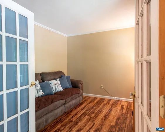 a bedroom with a bed and a window with wooden floor