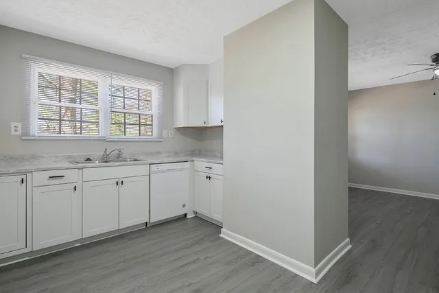 an empty room with wooden floor and window
