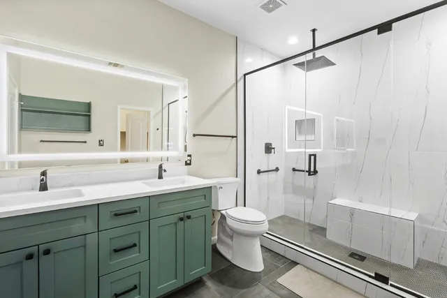 a bathroom with a double vanity sink toilet mirror and shower
