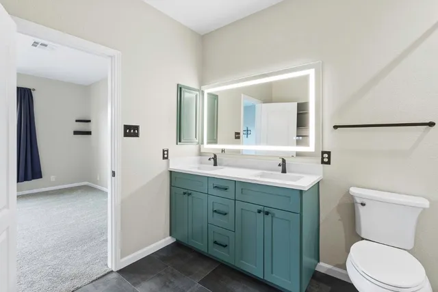 a bathroom with a toilet sink and mirror