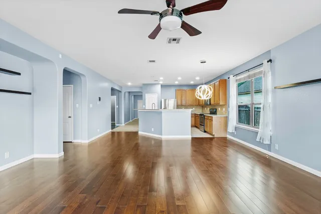 a view of a kitchen with wooden floor and a window