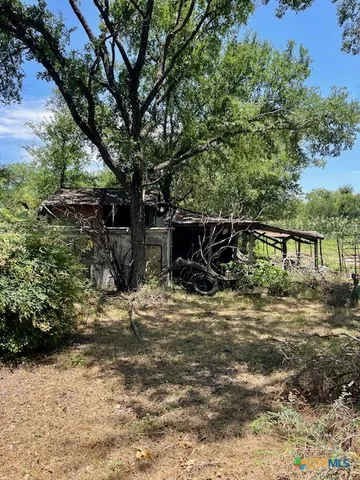 a view of a wooden house with a yard