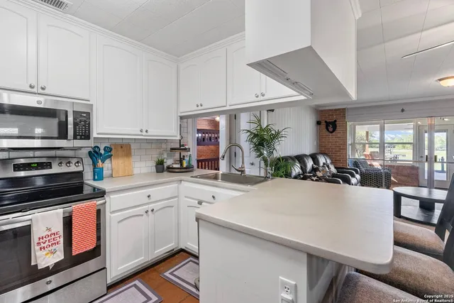a kitchen with a sink a stove and cabinets