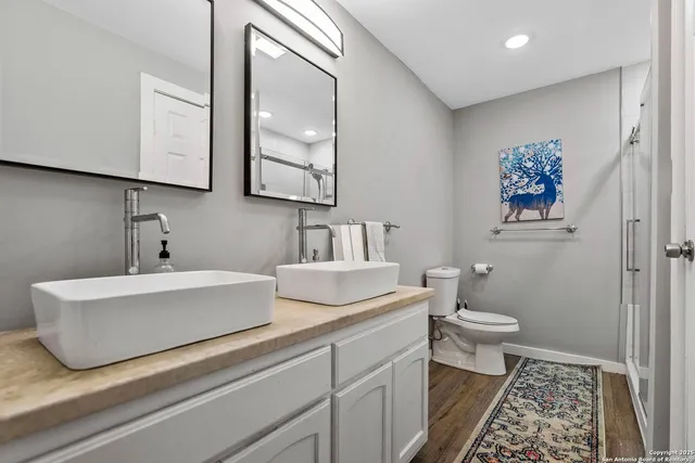 a bathroom with a sink a toilet and a mirror