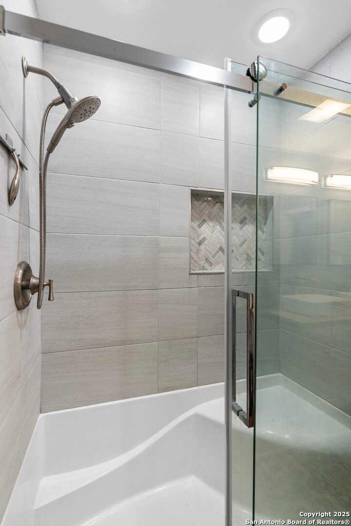 180 Freeman Circle George West, TX 78022 - Photo 18 of 41 a bathroom with a bathtub and a shower