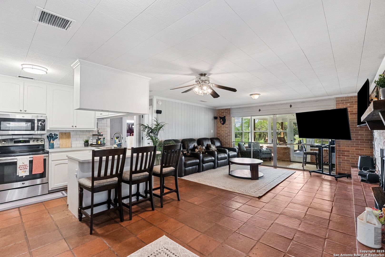 180 Freeman Circle George West, TX 78022 - Photo 2 of 41 a living room with furniture a flat screen tv and kitchen view