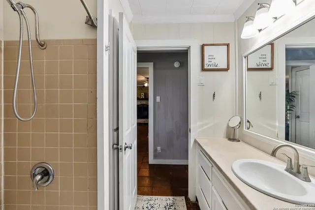 a bathroom with a sink a shower and a mirror