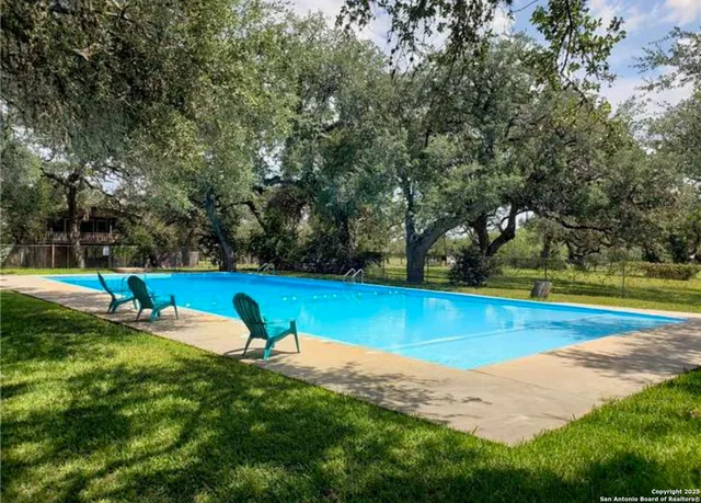 a view of a swimming pool with an outdoor seating and a forest