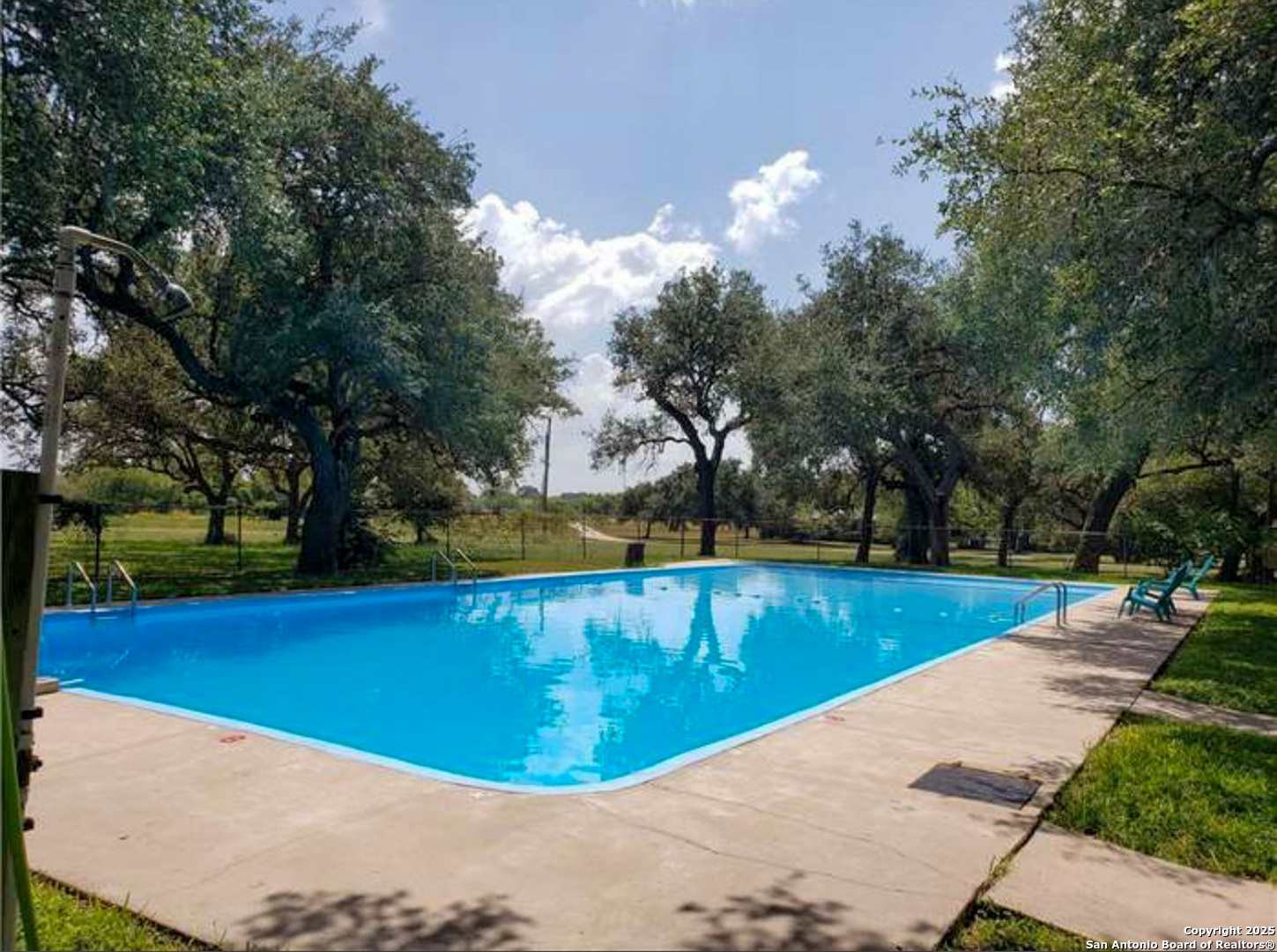 180 Freeman Circle George West, TX 78022 - Photo 41 of 41 a view of a swimming pool with an outdoor seating and a forest