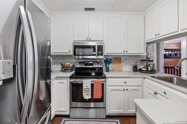 a kitchen with cabinets stainless steel appliances and a counter space