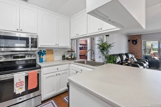 a kitchen with stainless steel appliances a stove a sink and a microwave