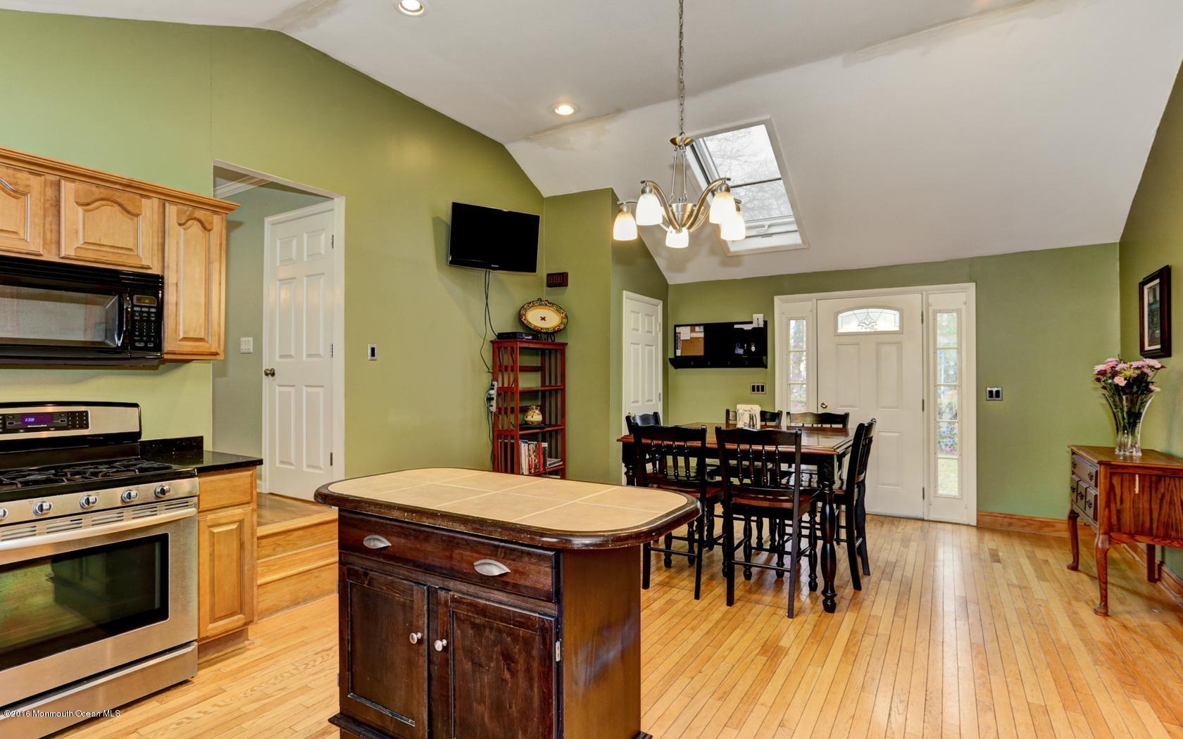 40 Drift Road Middletown, NJ 07718 - Photo 12 of 25 a kitchen with stainless steel appliances kitchen island granite countertop a stove a sink a dining table and chairs with wooden floor