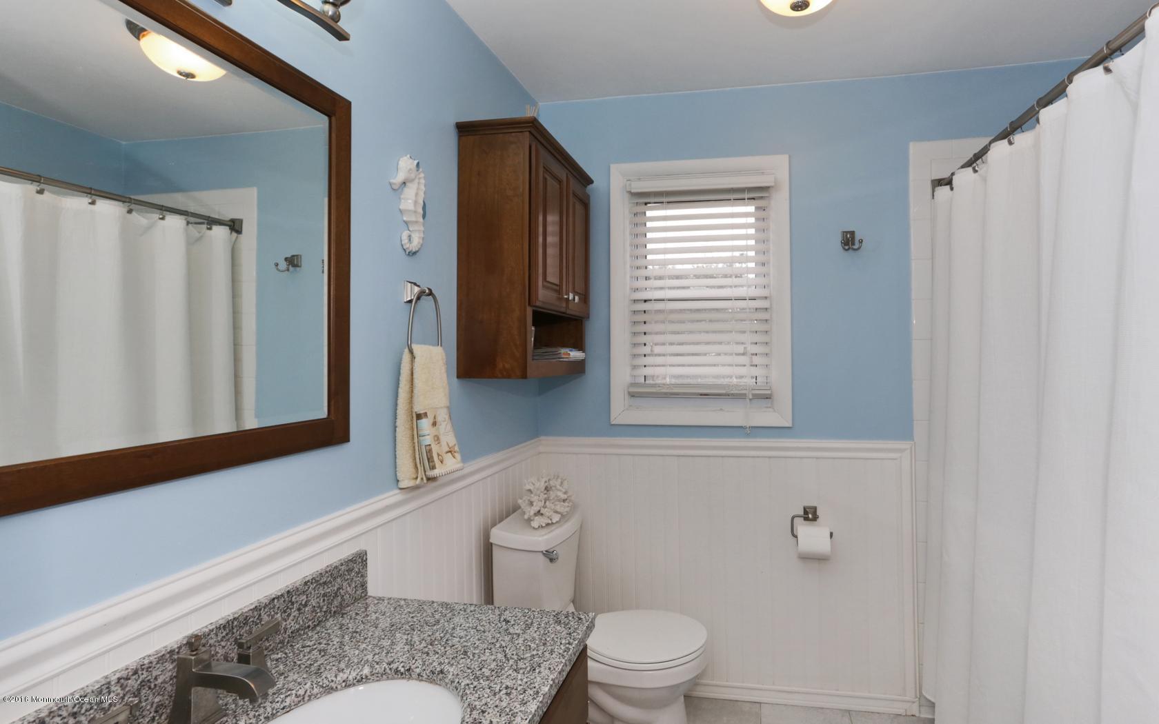 40 Drift Road Middletown, NJ 07718 - Photo 20 of 25 a bathroom with a granite countertop toilet a sink and a mirror
