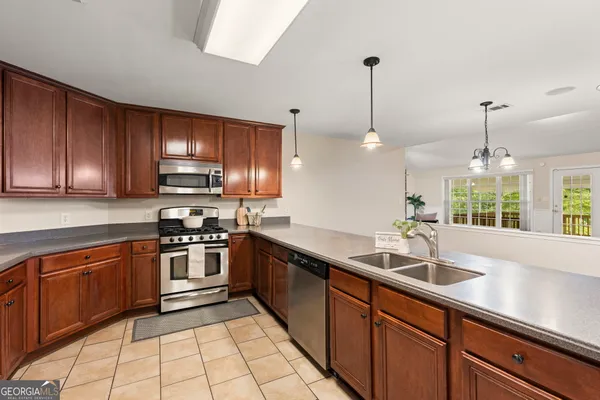 a kitchen with stainless steel appliances granite countertop a refrigerator stove top oven and sink