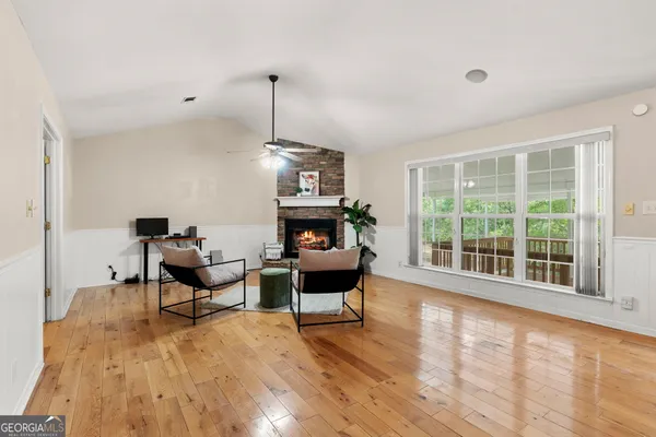 a living room with furniture and large wooden floor
