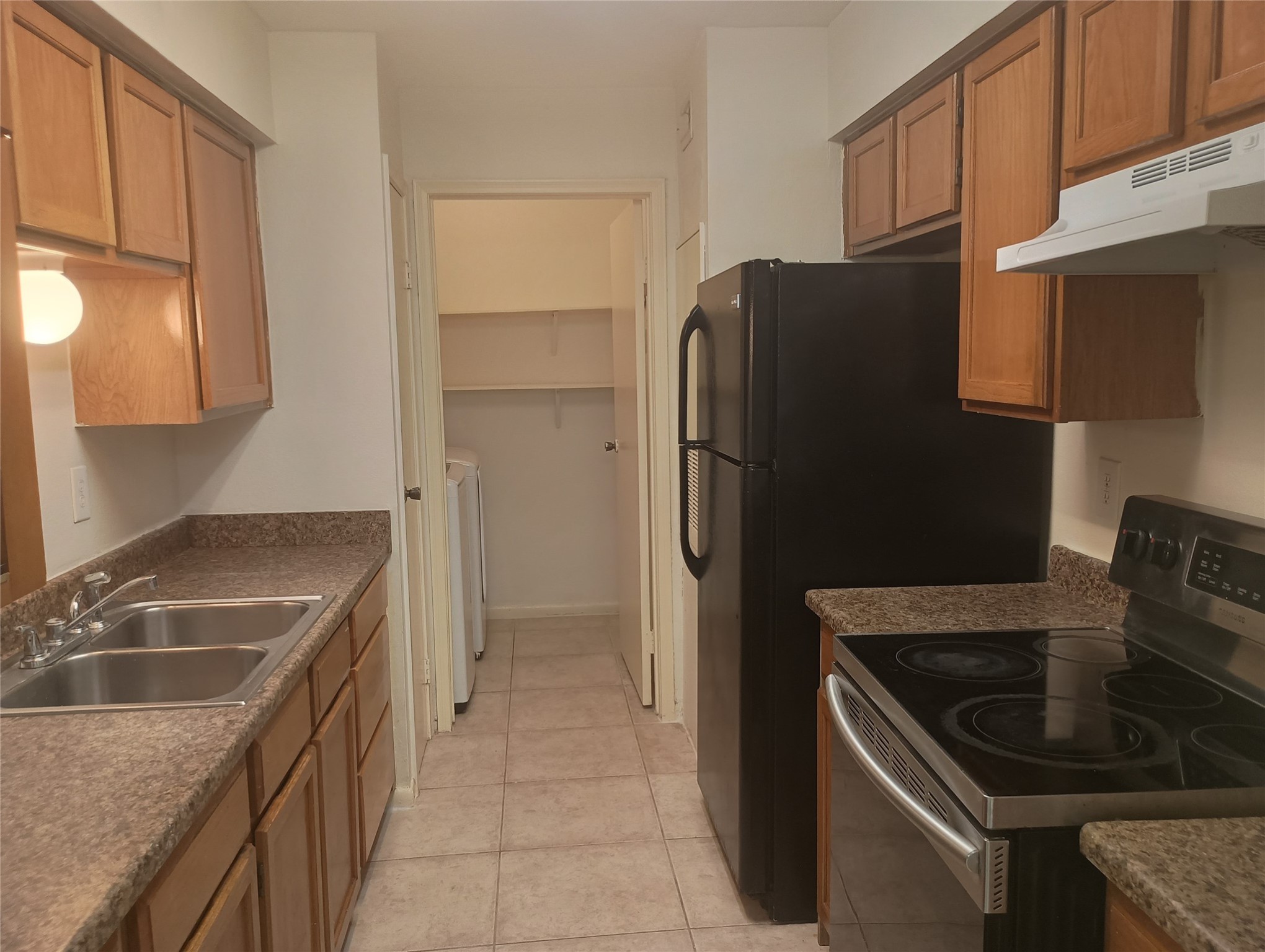 8787 Brae Acres Road, Unit 307 Houston, TX 77074 - Photo 4 of 15 a kitchen that has a refrigerator a sink and wooden cabinets