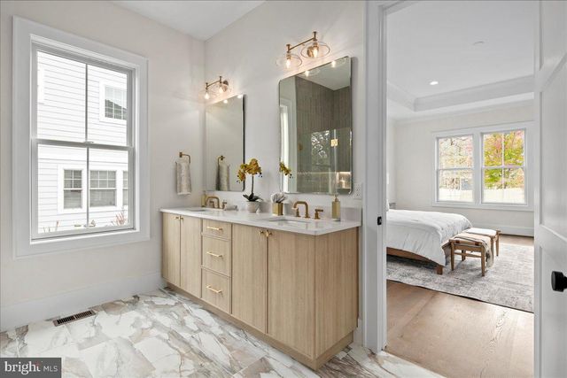 a en suite bathroom with sink mirror and window