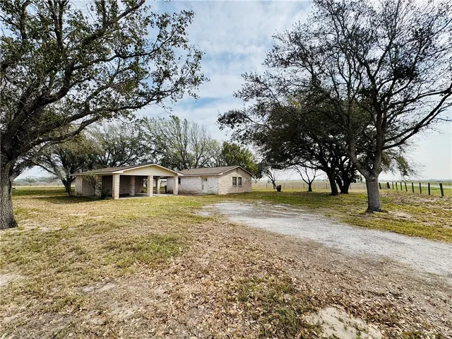 a front view of a house with a yard and trees