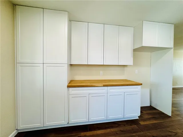 a view of kitchen with white cabinets and wooden floor