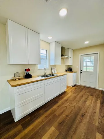 a kitchen with granite countertop a sink and white cabinets