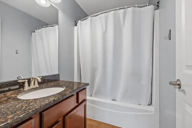 a bathroom with a granite countertop sink and a mirror
