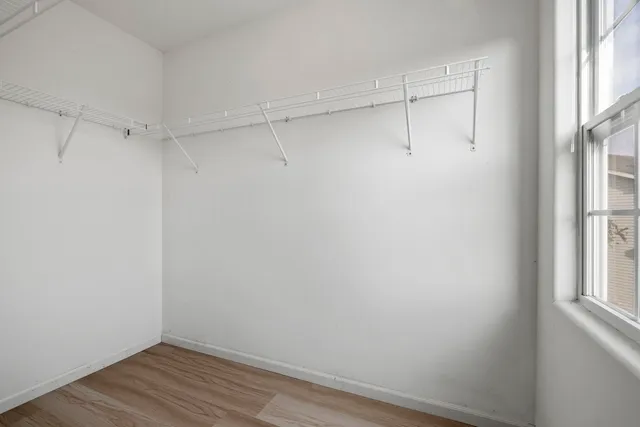 a view of a room with wooden floor and fan