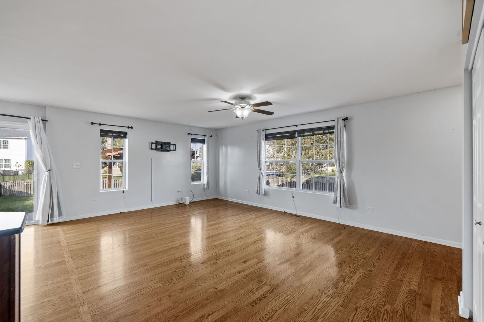 526 Lily Court Minooka, IL 60447 - Photo 3 of 26 a view of an empty room with a window and wooden floor