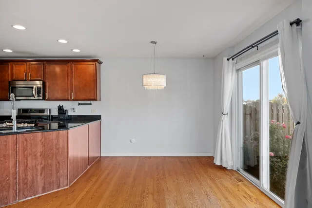 a kitchen with stainless steel appliances granite countertop a refrigerator a sink a stove a microwave oven with cabinets and wooden floor