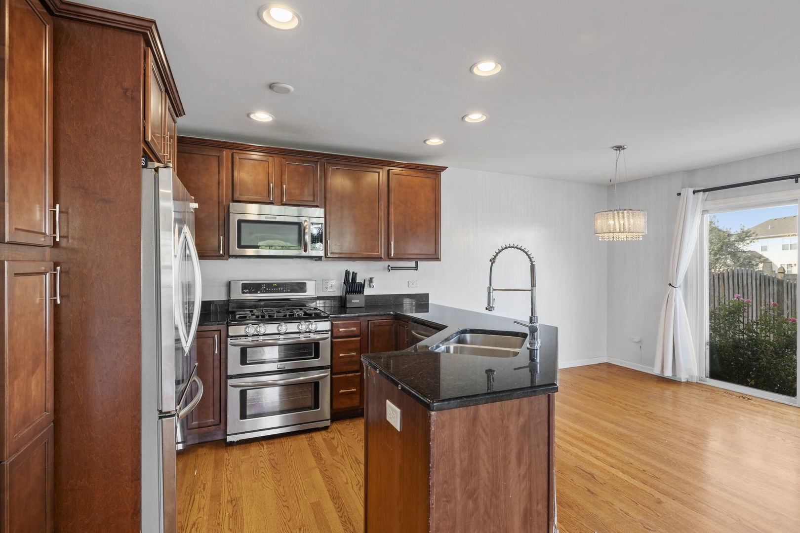 526 Lily Court Minooka, IL 60447 - Photo 6 of 26 a kitchen with stainless steel appliances granite countertop a stove a sink a refrigerator and a microwave