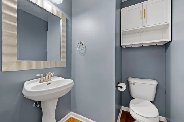 a bathroom with a toilet sink and mirror