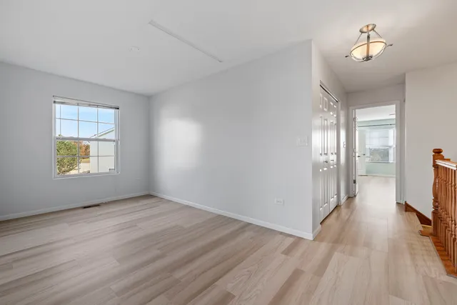 an empty room with wooden floor and a window