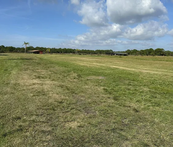 a kitchen with stainless steel appliances a refrigerator a stove a sink dishwasher and a dining table with wooden floor