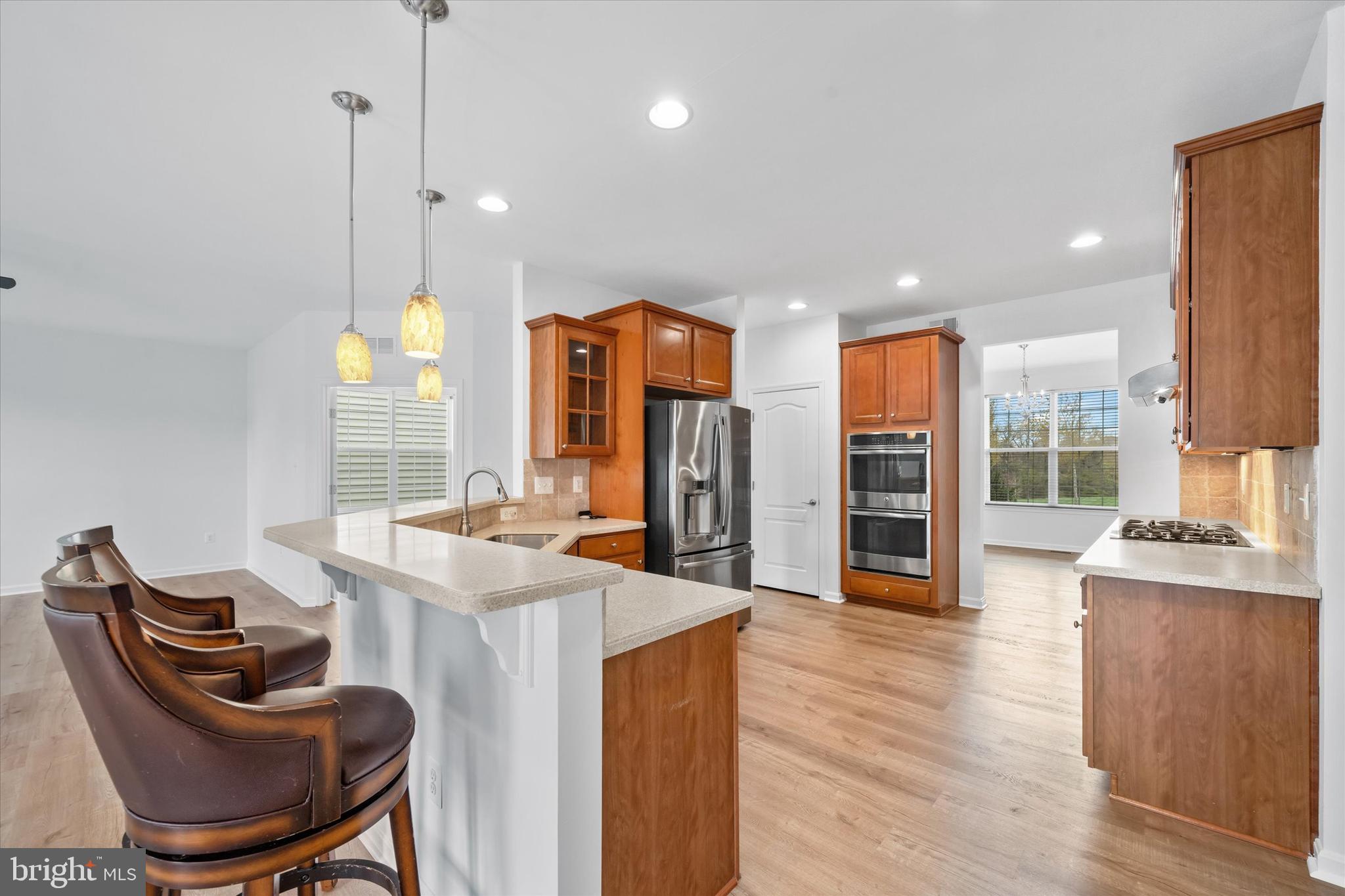 424 Winterberry Drive Middletown, DE 19709 - Photo 14 of 43 a kitchen with stainless steel appliances kitchen island granite countertop a stove a refrigerator and a wooden cabinets