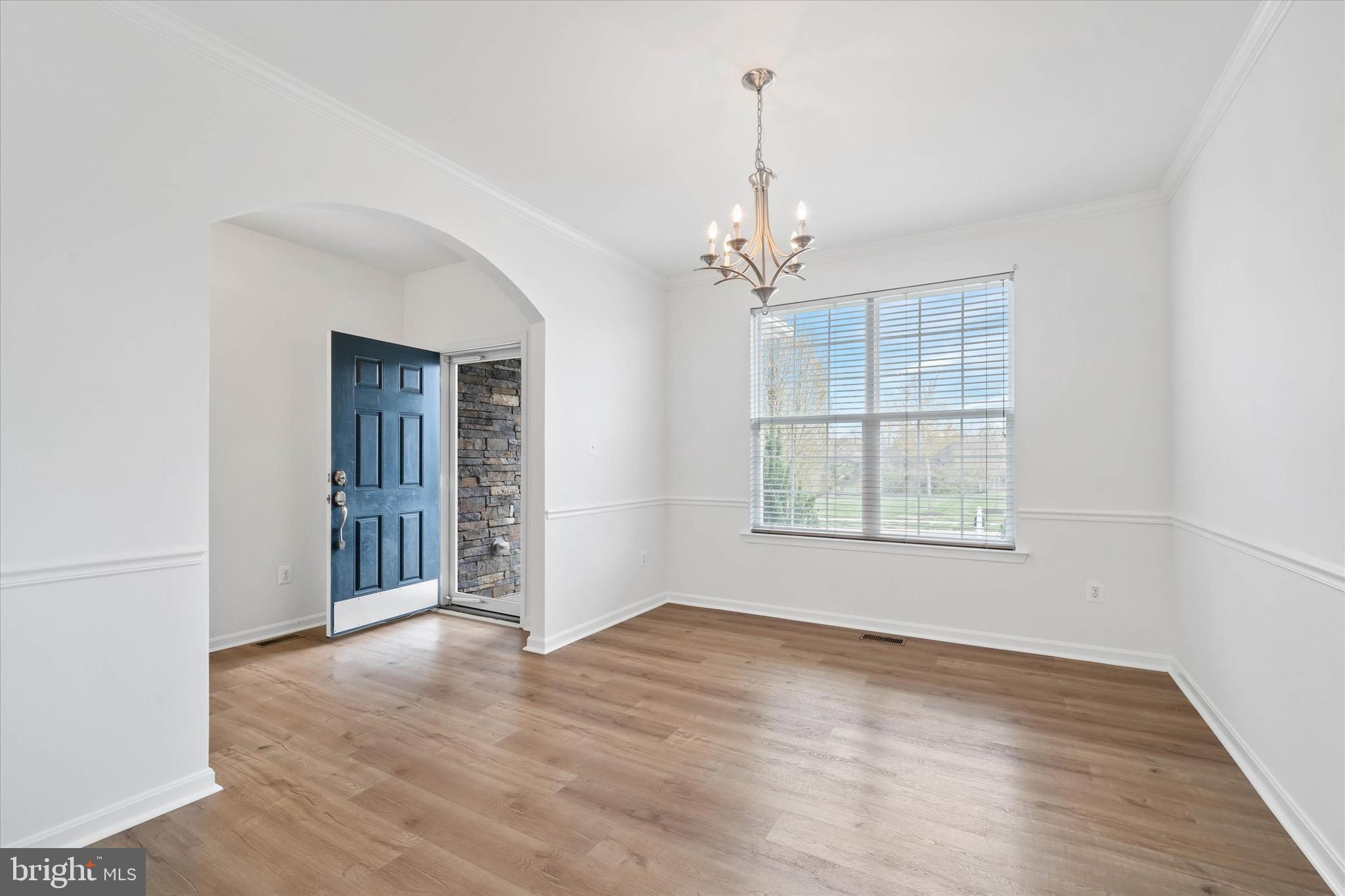 424 Winterberry Drive Middletown, DE 19709 - Photo 6 of 43 an empty room with wooden floor chandelier and windows