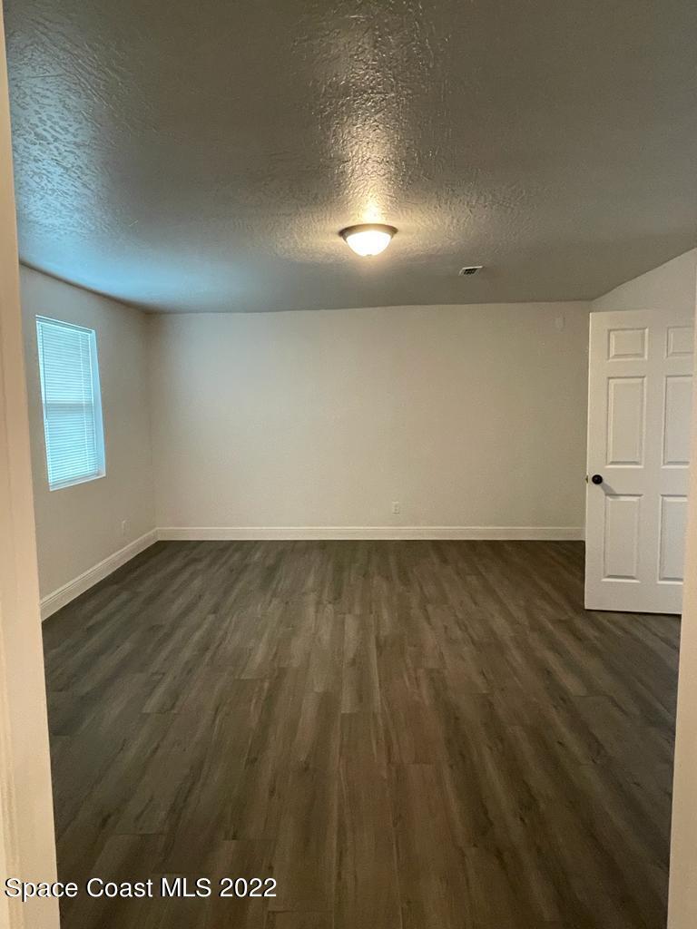 2262 Monroe Street Palm Bay, FL 32905 - Photo 11 of 15 an empty room with wooden floor and windows