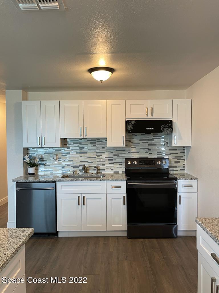 2262 Monroe Street Palm Bay, FL 32905 - Photo 4 of 15 a kitchen with stainless steel appliances granite countertop a stove a sink and a microwave