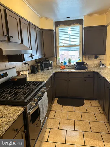 a kitchen with a sink stove top oven and cabinets