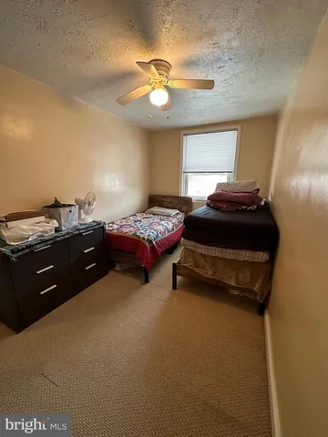 a bedroom with a bed and a ceiling fan