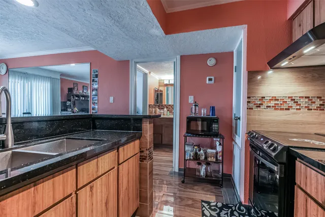 a kitchen with stainless steel appliances granite countertop a sink and a refrigerator
