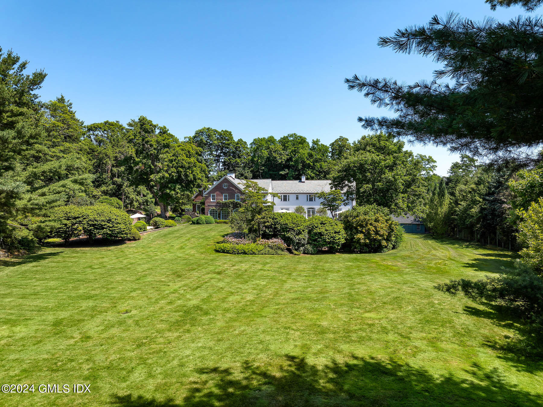 313 Stanwich Road Greenwich, CT 06830 - Photo 36 of 42 a view of a garden with a building in the background
