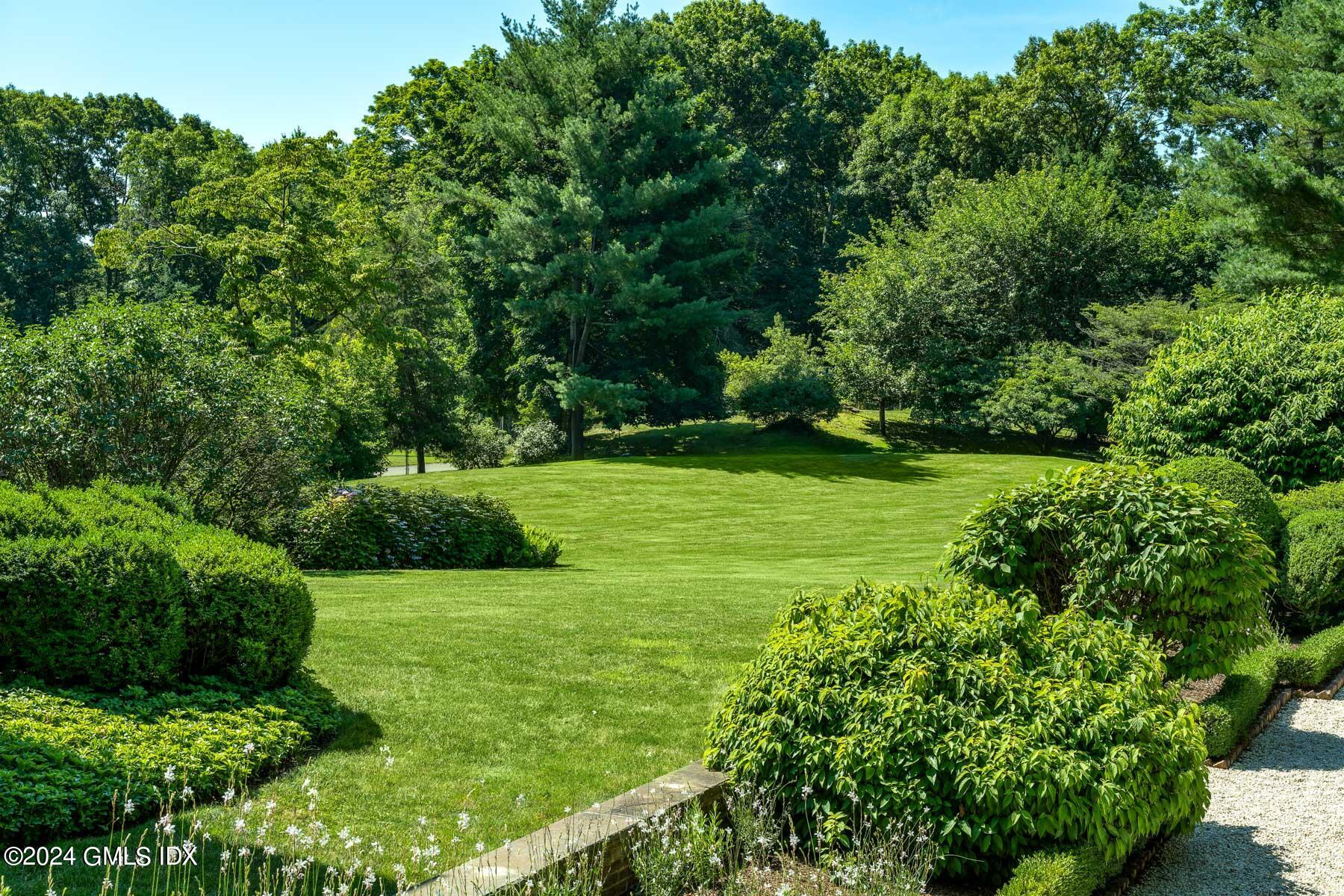 313 Stanwich Road Greenwich, CT 06830 - Photo 38 of 42 a view of a garden with a bench