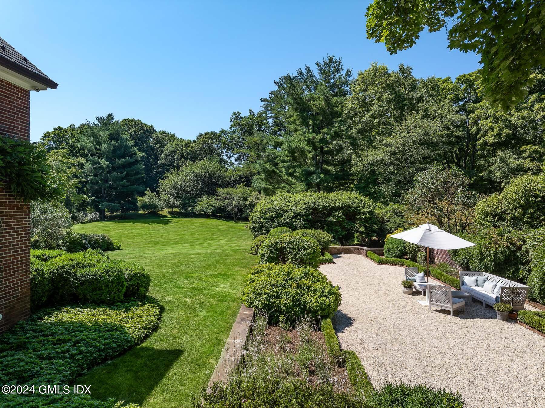 313 Stanwich Road Greenwich, CT 06830 - Photo 39 of 42 a view of a table and chairs under an umbrella