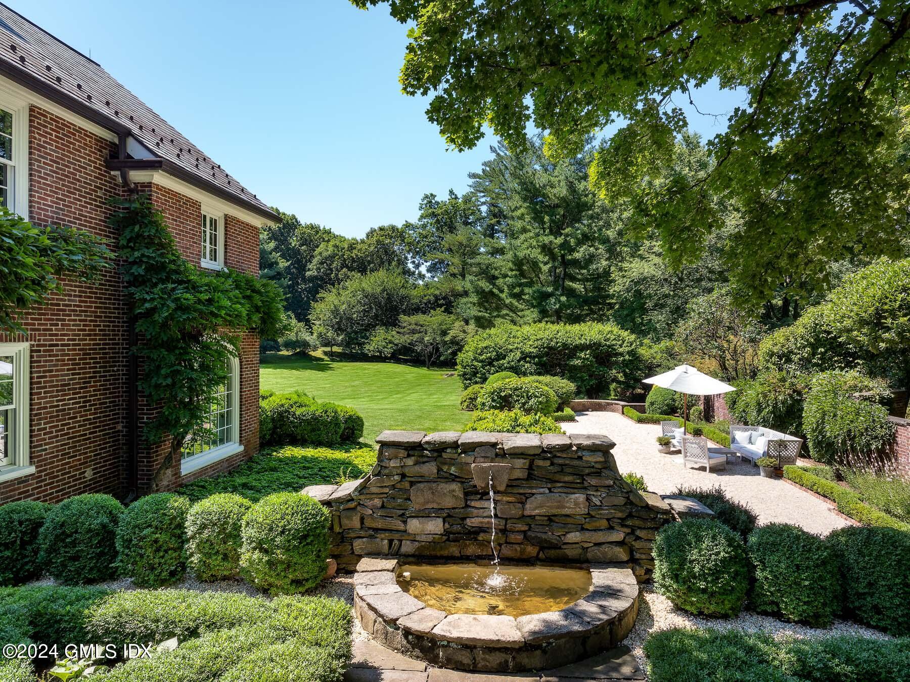 313 Stanwich Road Greenwich, CT 06830 - Photo 41 of 42 a view of a patio with lawn chairs under an umbrella