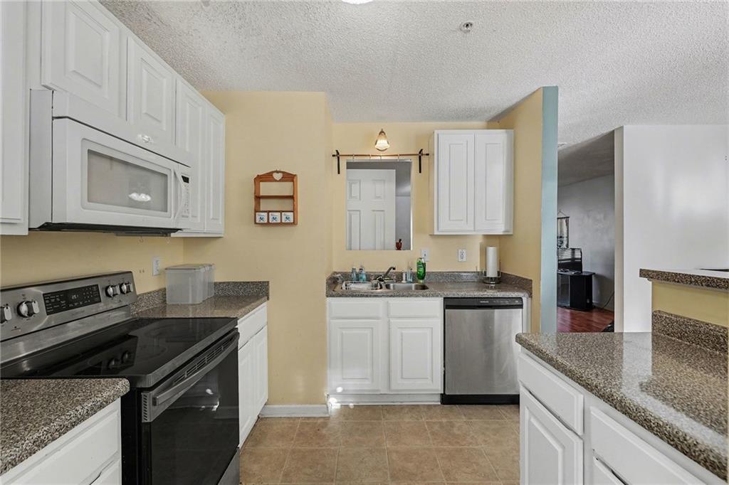 123 Chastain Circle Newnan, GA 30263 - Photo 16 of 27 a kitchen with kitchen island granite countertop a sink stove and refrigerator
