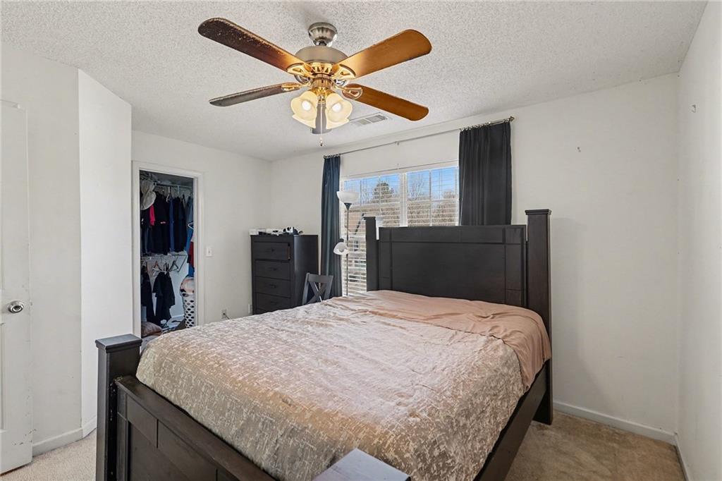 123 Chastain Circle Newnan, GA 30263 - Photo 18 of 27 a bed room with a bed and a ceiling fan