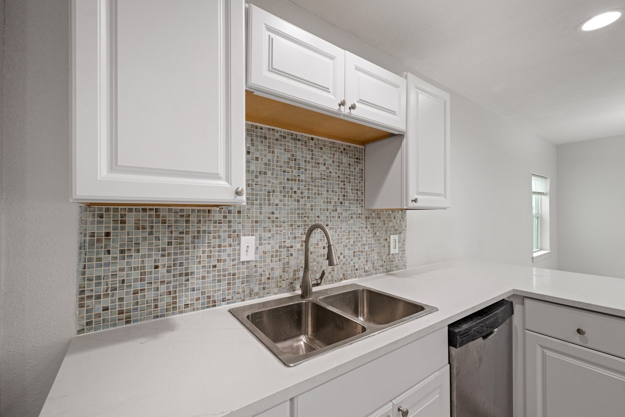 1426 Shawnee Street Houston, TX 77034 - Photo 16 of 34 Take a look at the beautiful cabinets, and quartz counter tops. The mosaic tile back splash offers a modern touch.