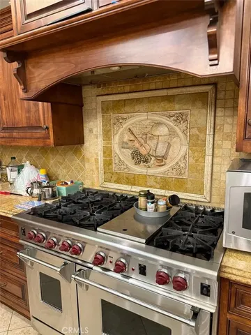 a kitchen with stainless steel appliances granite countertop a sink a stove and a wooden floors
