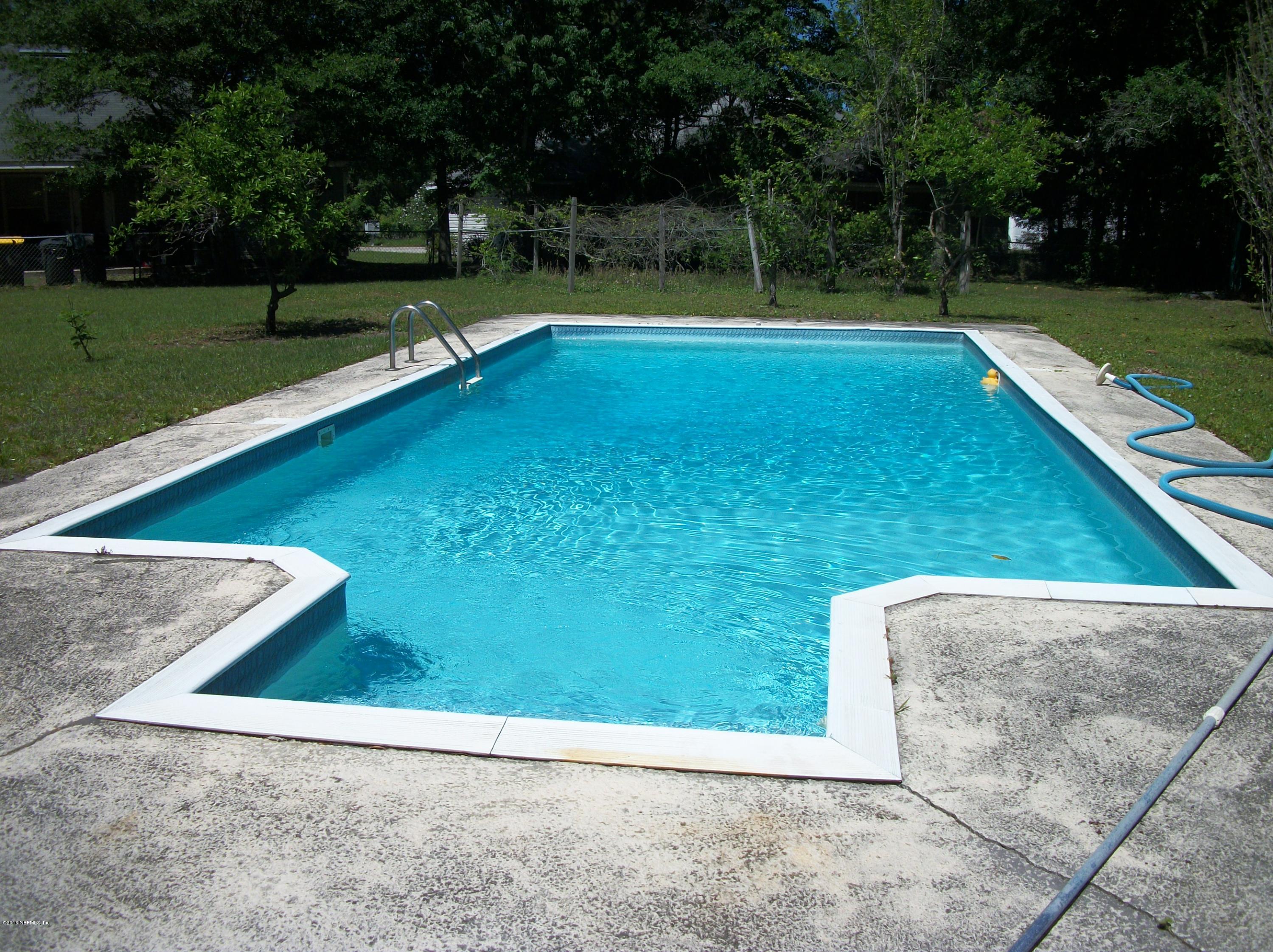 a view of a backyard with swimming pool