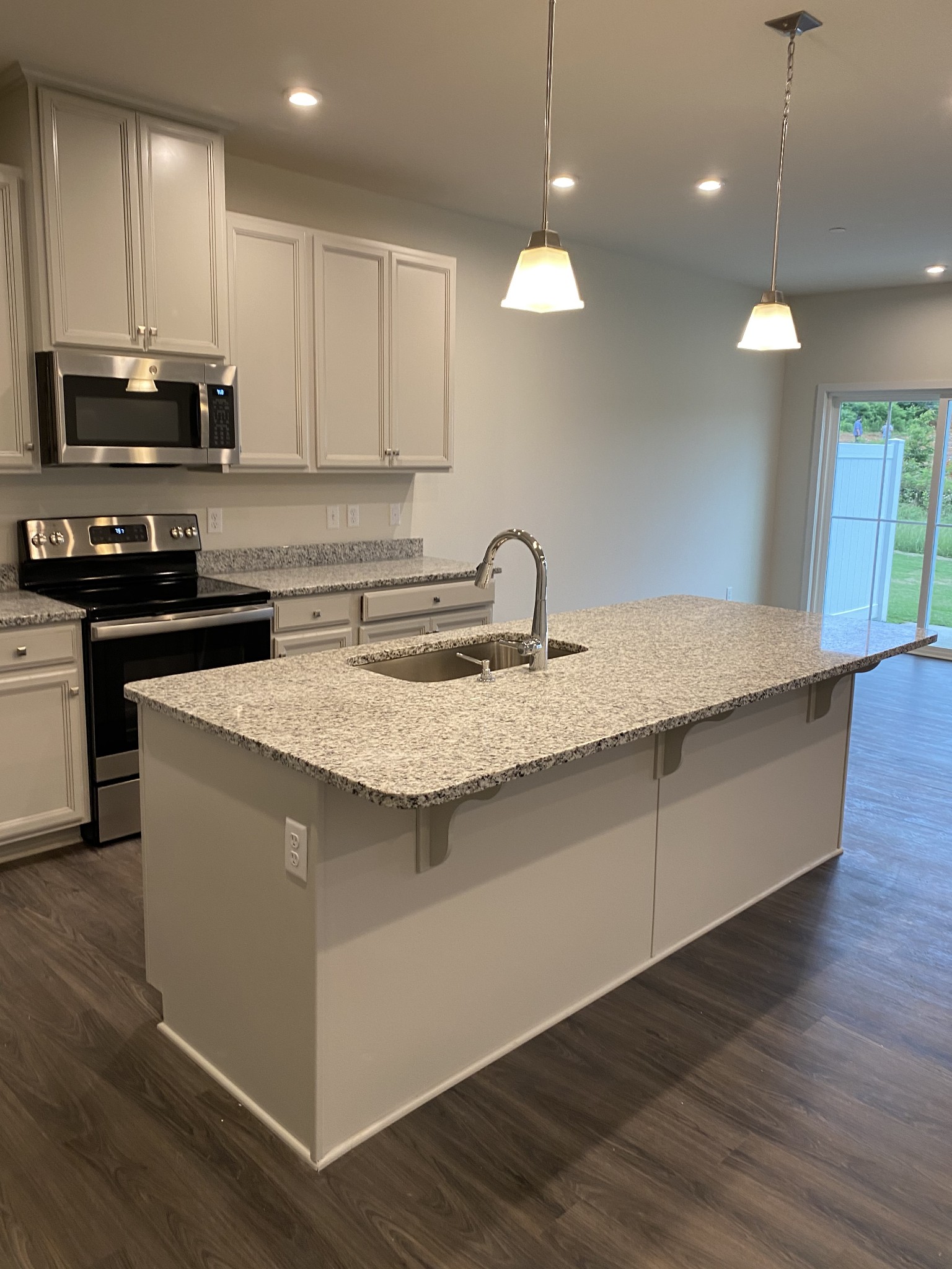110 Keelon Gap Road, Unit 104C Spring Hill, TN 37174 - Photo 6 of 22 a kitchen with kitchen island granite countertop a sink a counter space appliances and cabinets